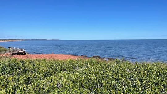 Red sand beach, ocean, blue sky