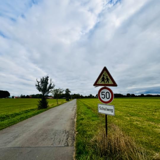 Ein Schulwegschild an einer menschenleeren Landstraße