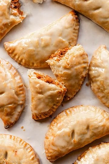 close-up of glazed pumpkin hand pies on parchment paper.