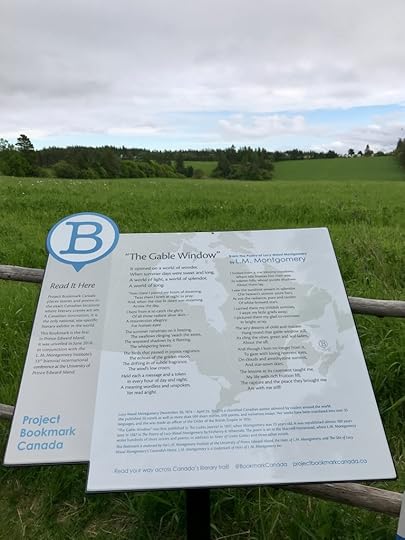 Bookmark plaque for “The Gable Window,” by L.M. Montgomery, with green fields in the distance