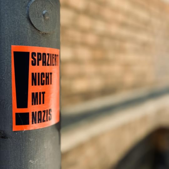 Ein roter Aufkleber an einem Laternenpfahl: Spaziert nicht mit Nazis!