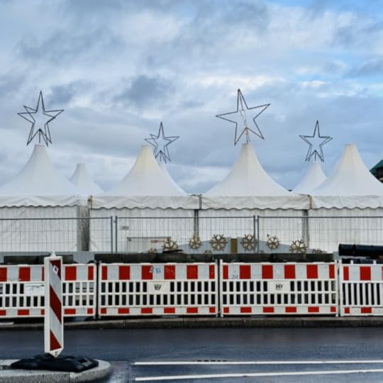 Die weißen Pavillonzelte des Weihnachtsmarktes auf dem Jungfernstieg von der Rückseite, mit großen, unbeleuchteten Sternen auf den Dächern, davor rotweiße Absperrgitter, kein sehr heimeliger Gesamteindruck
