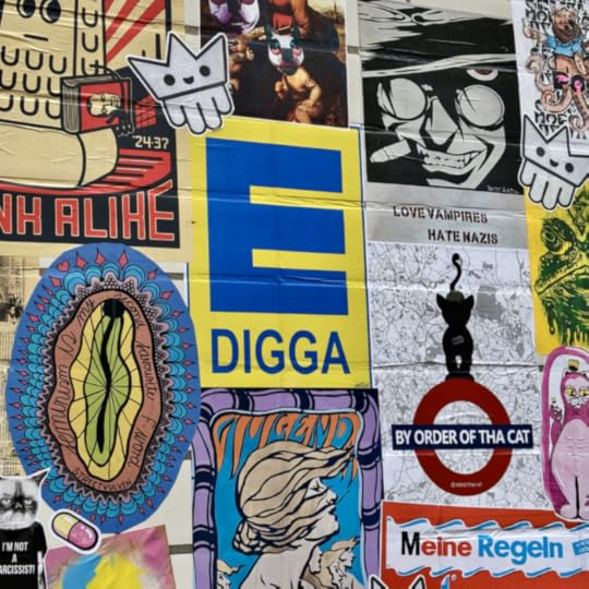 Eine streetartmäßiug beklebte Wand, ein Plakat zeigt das E von Edeka mit einem nachgestellten Digga