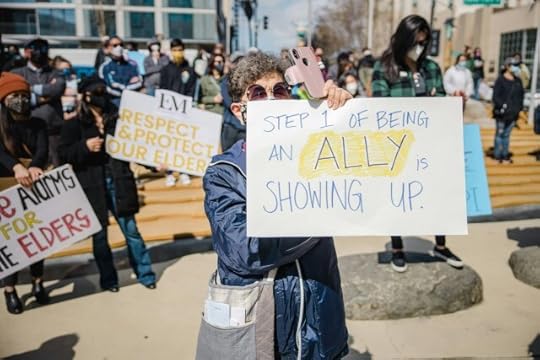 Protestor holding a sign that reads “step 1 of being an ally is showing up”. How not to let the haters win.