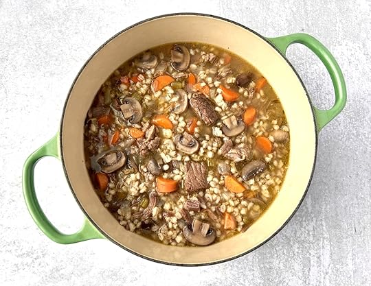 dutch oven with cooked beef barley soup with mushrooms