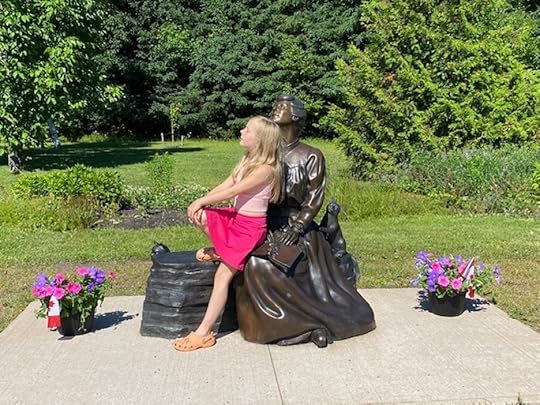 A girl posing with the L.M. Montgomery statue in Cavendish, PEI