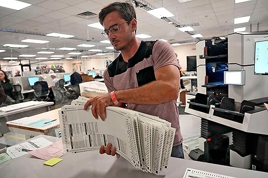 An elections official sorts counted mail-in ballots on the first day of tabulation