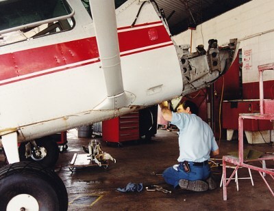 aircraft technician, displaying an overcomers attitude, repairs nose gear of single engine airplane