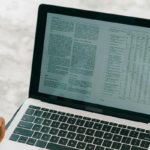 Close-up of a person reviewing a detailed document on a laptop screen.
