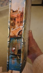 The sprayed edges of The Glass Maker by Tracy Chevalier showing a scene of Venice with a gondolier.