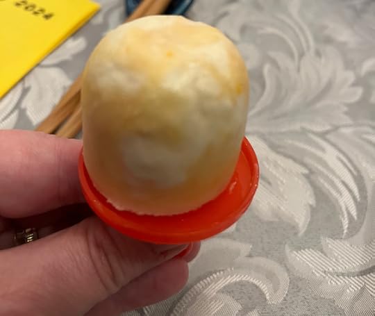A small round orange and white popsicle