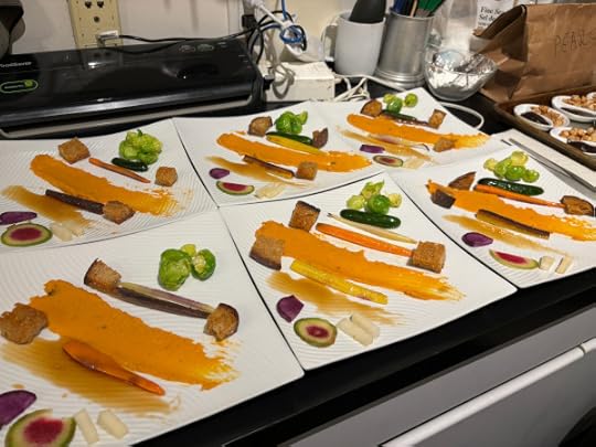 Square white plates, each one arranged kind of like a piece of modern art with colorful vegetables in varying shapes.