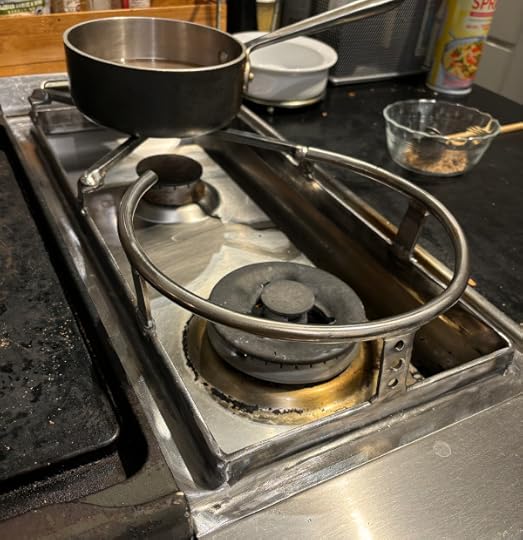 A stainless steel ring welded to a stand on a stove. 