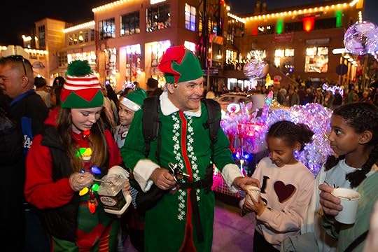 Elves Gabi Amselei, left, and Mike Cook hand out hot...
