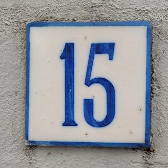 White tile with blue number 15 in centre and blue rim.