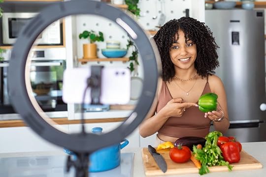 A nutrition coach uses a camera and ring light to film a video about the benefits of eating more vegetables.