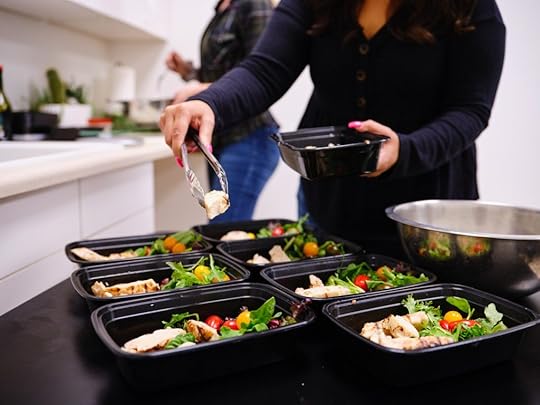Nutrition coaching clients batch-cook a meal and divide it up into single-serving containers.