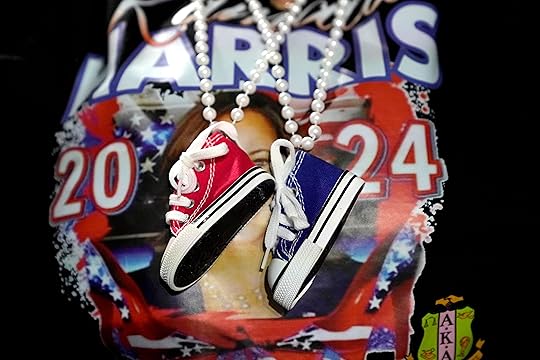 A supporter wears decorative Converse sneakers on a necklace as Democratic presidential nominee Vice President Kamala Harris speaks at a campaign rally