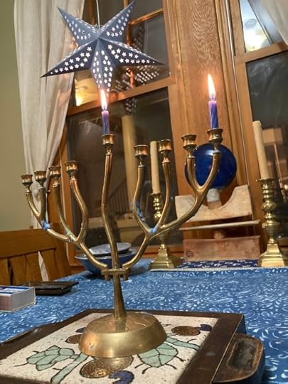 Hannukah menorah in a tree shape with a blue star lantern in the background.