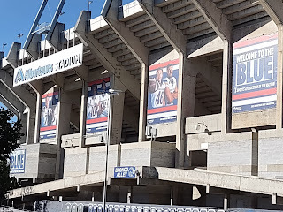 Image of Albertson's Stadium. Three banners of football players, followed by a fourth banner that says WELCOME TO THE BLUE