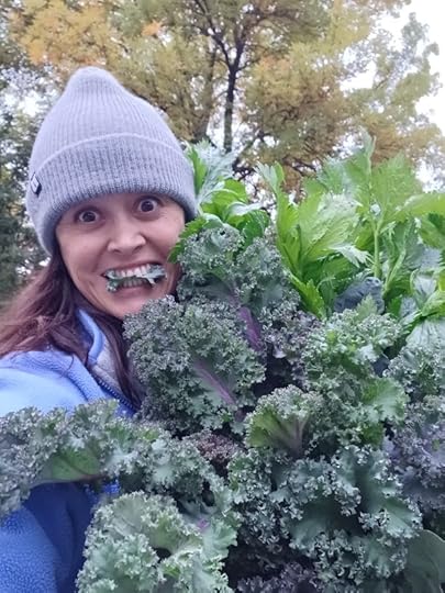 Gardener in a hat eating just harvested kale in the fall