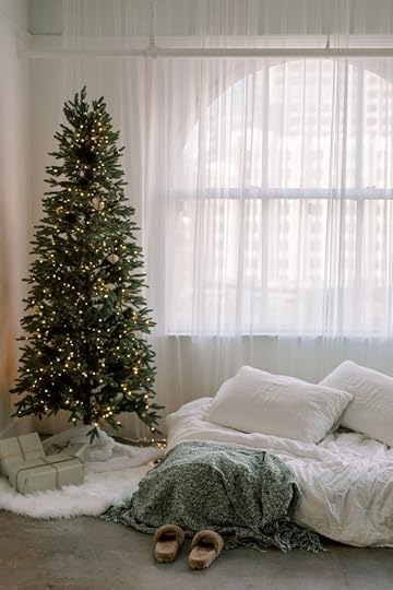 cozy bed beside a decorated Christmas tree. Perfect for reading sweet holiday romance books.