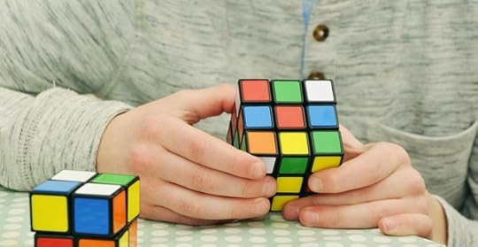 Person in a gray shirt holding a rubik's cube