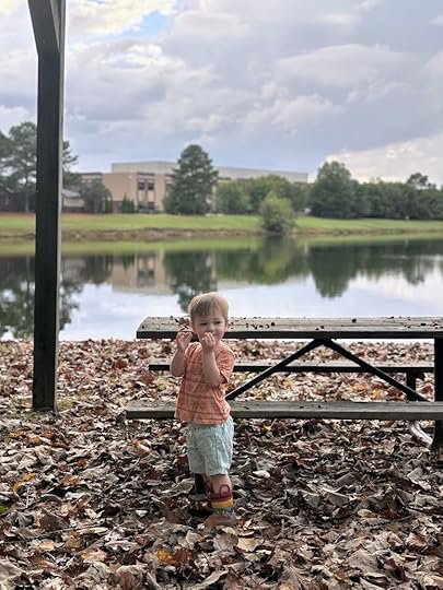 a child standing on a bench near a lake