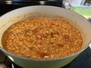 A yellow Dutch oven containing butternut squash red lentil soup. The soup hasn't been blended so the vegetables are still intact