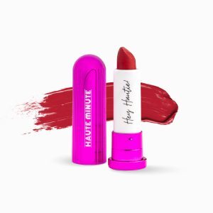 Miniature size, bright red lipstick in a flourescent magenta tube against a white background
