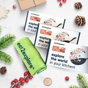 Boxed kits containing recipes for baking and savory foods, on a holiday-themed background