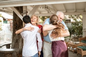 young couple hugging older couple