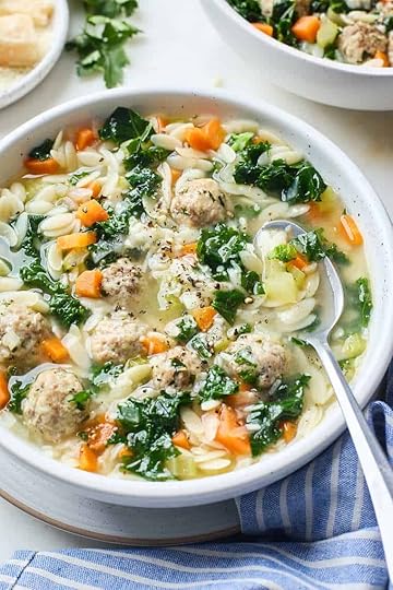 A close up of a bowl with a spoon of Italian Wedding Soup ready to serve
