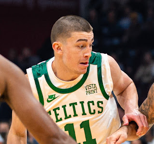 Image on an individual in a white basketball jersey with green lettering and green trip. Jersey reads Celtics, with the number 11 underneath. Near right shoulder a Nike patch and left shoulder, a patch that says Vista Print