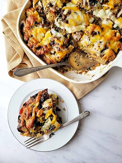 A portion of sausage strata on a plate, with the casserole dish nearby.