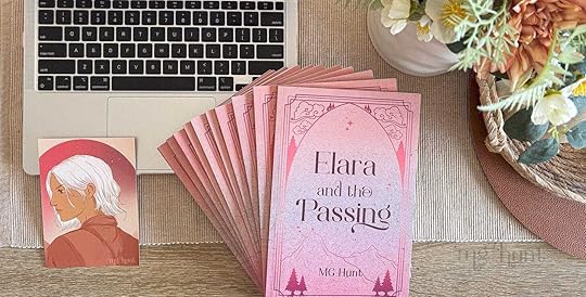 Flat lay of a stack of books title 'Elara and the Passing'. Behind it, there is a Mac laptop with the keyboard showing. There is a portrait illustration next to the stack of books, and it depicts the main character, Elara. To the right of the book stack, there is a bunch of Australian native flowers in a vase.