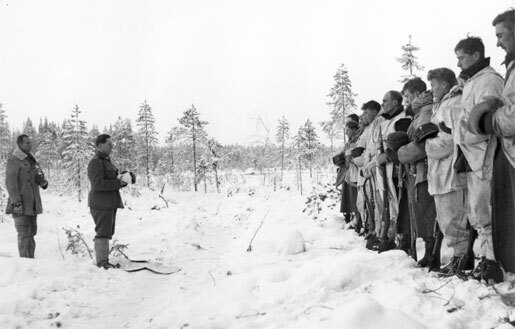 Finnish Army Lieutenant Aarne Juutilainen and his company holding a Christmas service near the Kollaa River, Finland, 24 Dec 1939 (public domain via Wikipedia) 