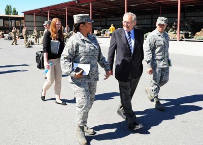  Col. Shirlene Ostrov, 376th Expeditionary Mission Support Group commander, left, and Lt. Col. Tom Doan, 376th Expeditionary Logistics Readiness Squadron commander, right, guide former Secretary of Defense Donald Rumsfeld, center, after completing a tour of the customs processing center baggage yard at Transit Center at Manas, Kyrgyzstan, June 20, 2013. Photo by Staff Sgt. Krystie Martinez, courtesy of the U.S. Air Force.