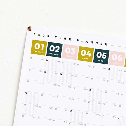 May include: 2025 year planner featuring a monthly calendar view. Each month is represented by a color-coded square: January (gold), February (dark teal), March (light pink), April (gold), May (dark teal), and June (light pink). The planner is designed with a clean, minimalist aesthetic and includes days of the week labels.