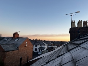 Dawn on January 2nd, blue sky looking out over rooftops with chimney pots