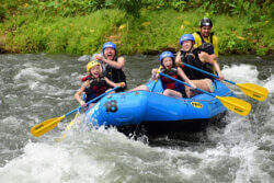 Family with younger kids rafting on river