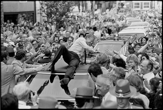 President Jimmy Carter leans across the roof of his car to shake hands along the parade route through Bardstown, Ky.