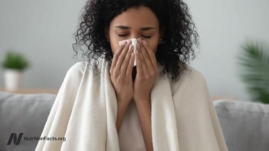 Woman sneezing into a tissue
