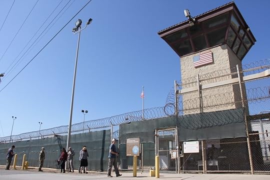 People walk past a guard tower outside the fencing of Camp 5 at the the U.S. military's prison in Guantanamo Bay, Cuba, on Jan. 26, 2017.