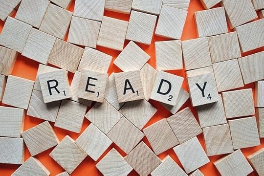scattered Scrabble tiles face down with a set of tiles face up spelling
