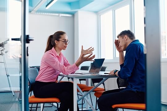 Looking into a meeting room where a manager is talking to an upset employee