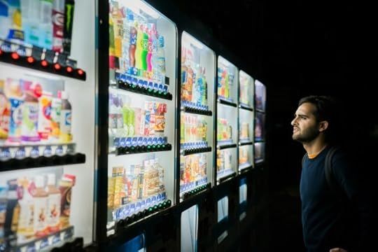 A man in front of vending machines. You can choose your own life.