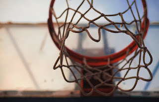 Image of a basketball rim and net, outdoors, with the viewpoint from underneath, looking up at the net