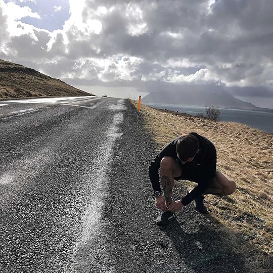 The author lacing up his shoes on a long road in Iceland