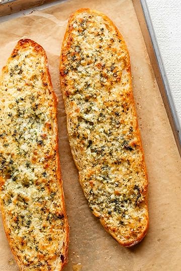 baked homemade garlic bread on parchment paper-lined baking sheet.
